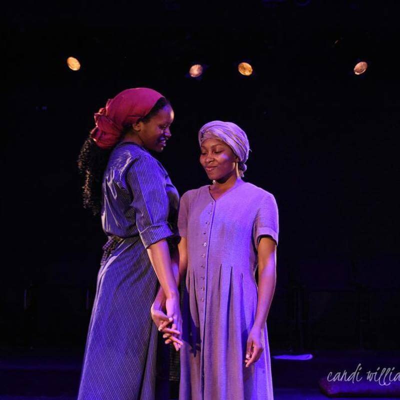 Howard University theatre performers in costume onstage.