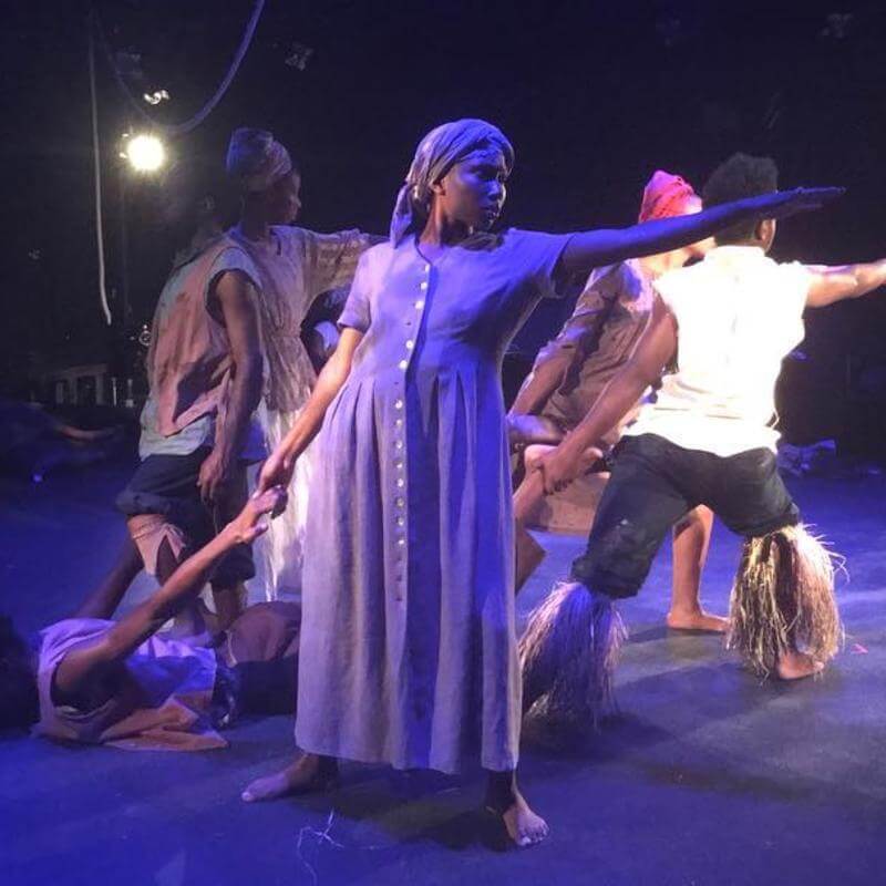 Howard University theatre performers in costume onstage.