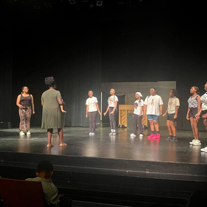 students on stage in a voice class singing
