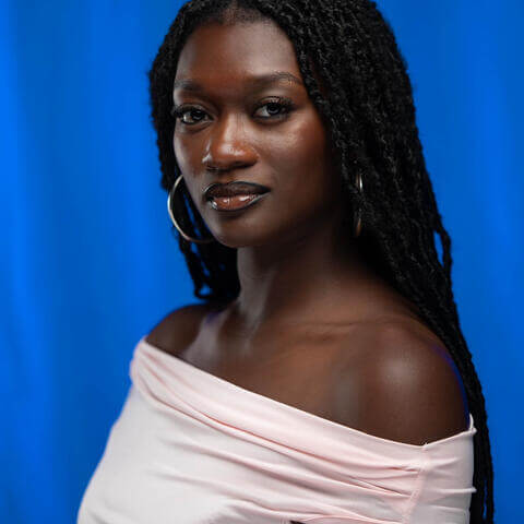 Nia Potter, African American female with long black hair and off the shoulders, pink shirt