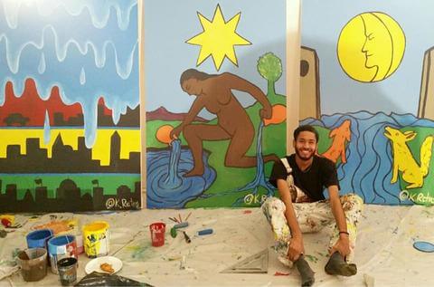 A student artist with three large paintings.