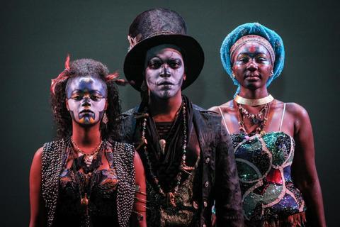 Three Howard University theatre arts performers in costume standing side-by-side.