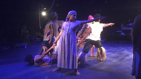 Howard University theatre performers in costume onstage.