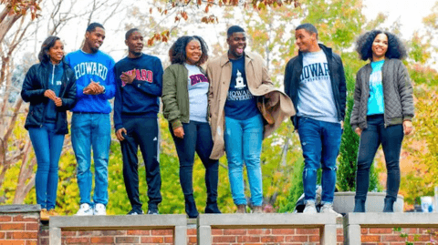 Howard U students standing on wall with various clothing