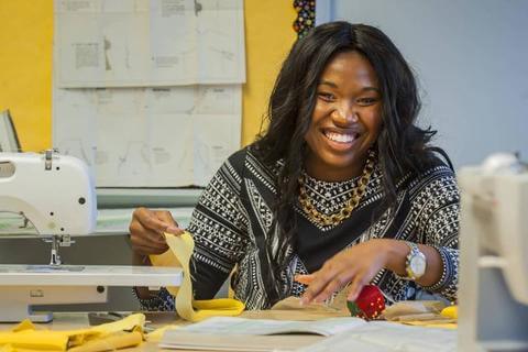 A Howard University student using a sewing machine.