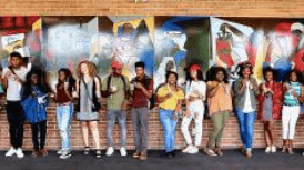 Students standing in front of a colorful painting