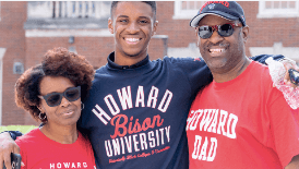 African American mother, child, father standing together with red and blue Howard U shirts on.