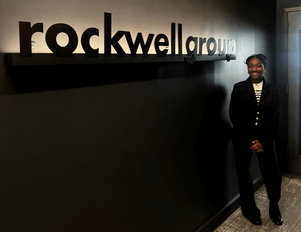 Student in front of Rockwell Group Sign
